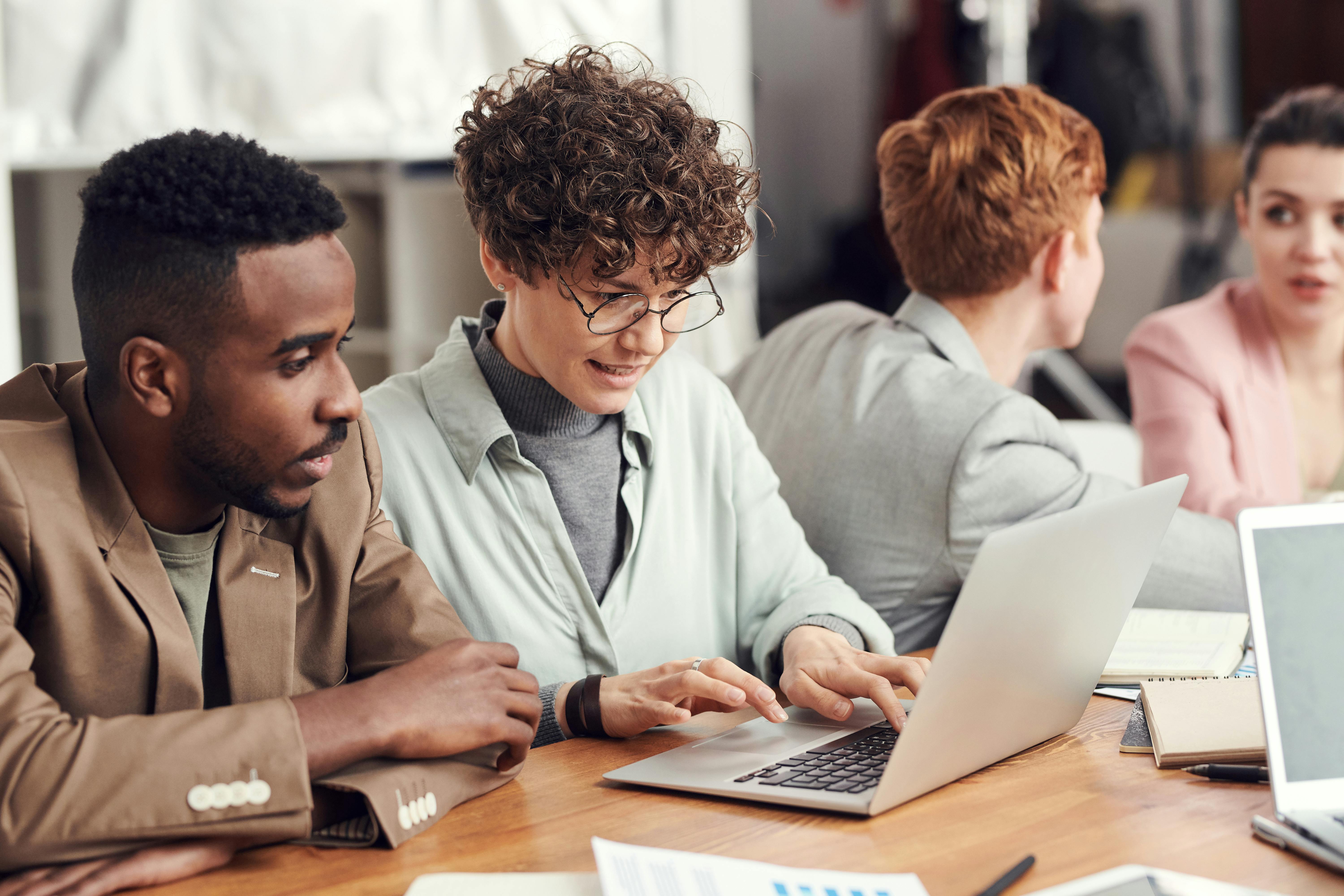 Equipe reunida analisando uma solução de inteligência artificial em um notebook